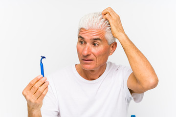 Senior caucasian man holding a razor blade isolated çbeing shocked, she has remembered important...