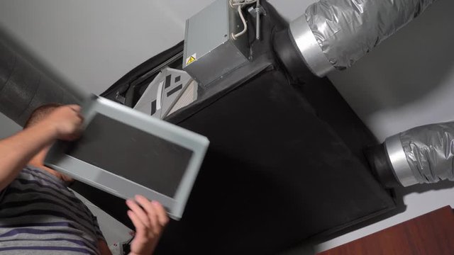 man inspecting air quality control filters. Modern air ventilation system