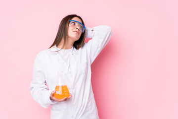 Young chemical woman isolated touching back of head, thinking and making a choice.