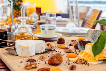 Selective focus shot of a heart-shaped cheese on a wooden tray