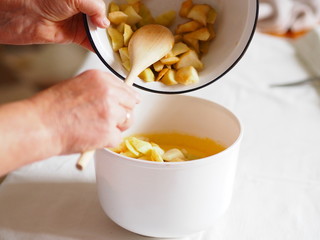 Woman's hands are preparing a pie at home. combine different baking ingredients.