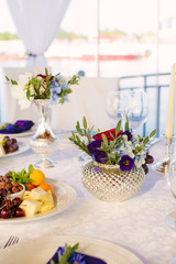 Floral arrangement of green and purple flowers in the wedding decor of a Banquet table