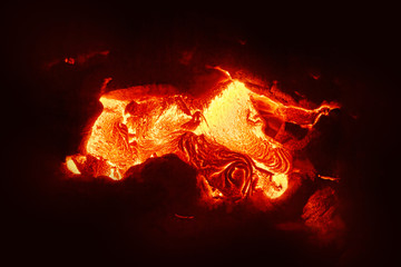 Detailed view of an active lava flow, hot magma emerges from a crack in the earth, the glowing lava...