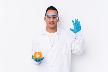 Young latin cientific man isolated  smiling cheerful showing number five with fingers.