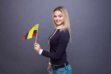 Immigration and the study of foreign languages, concept. A young smiling woman with a Colombia flag...