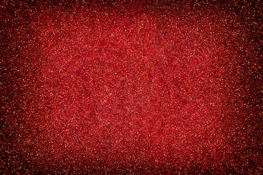 red sparkling background from small sequins, closeup. Brilliant shiny backdrop from textile.