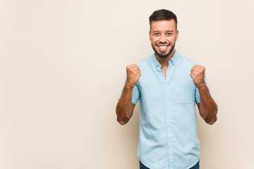 Young south-asian man cheering carefree and excited. Victory concept.