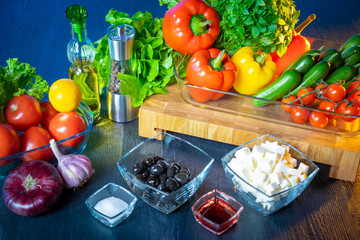 Greek salad. Learning how to make a salad. Illustration for a recipe book. Salad dressing. Vegetables ready to cook side dish. Black olives and cheese. Onions, garlic, paprika, tomatoes, lemon.