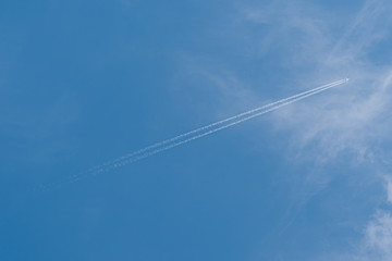 Fototapeta na wymiar Plane in the sky. Blue background and clouds.
