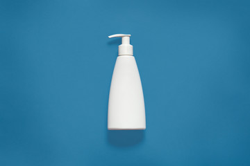 Packing with liquid soap isoaltedover blue studio background, cosmetic white empty plastic bottle with clipping path, front view of cosmetic container with copy space for advertisment. Mock up.