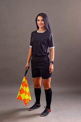 Beautiful Soccer Referee with flag in hand looking at camera and smile