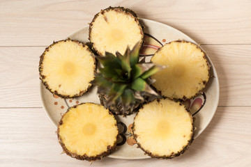fresh and juicy pineapple pieces on a yellow homogeneous surface. Fruit ready to eat