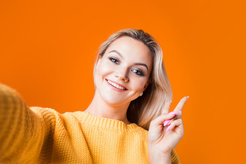 Cute blonde makes selfie on the front camera, the portrait