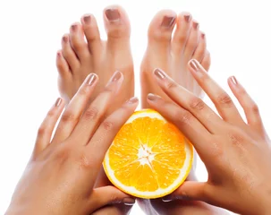 Selbstklebende Fototapeten manicure pedicure on afro-american tan skin hands holding orange, healthcare spa concept © iordani