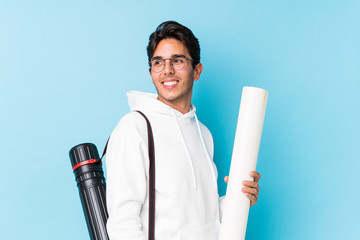 Young caucasian man studying architecture isolated looks aside smiling, cheerful and pleasant.