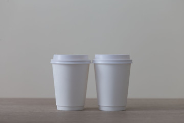 Food. White paper cup cappuccino in beige background
