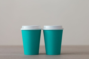 Food. Turquoise paper cup cappuccino in beige background