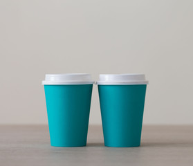 Food. Turquoise paper cup cappuccino in beige background