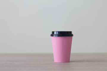 Food. Pink paper cup cappuccino in beige background