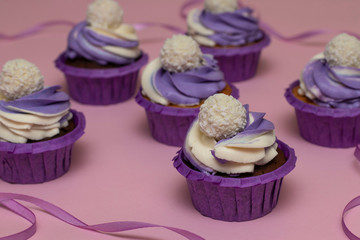 Homemade cupcakes with lilac cream on a pink background, concept for Valentines day or birthday, horizontal orientation