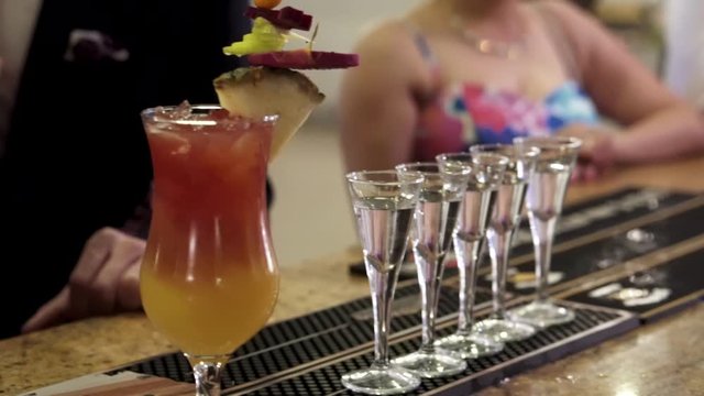 Fruit Cocktail Next Row Of Shot Glasses At Bar With People In The Background