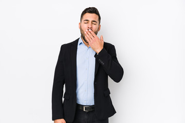 Young caucasian business man against a white background isolated yawning showing a tired gesture covering mouth with hand.