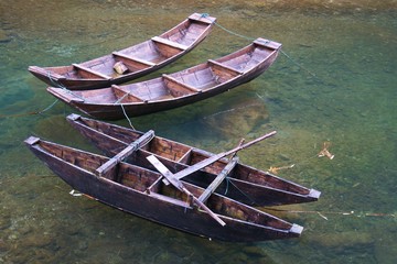 Four wooden row boats in shallow water in China