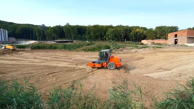 A large road Roller compacts the ground for large construction