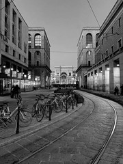 View of the city center of Milan, in background galleria Vittorio Emanuele II in black and white.