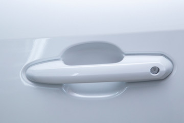 The car door handle is white. Exterior of the car.