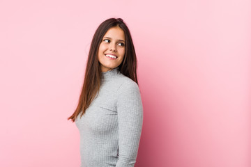 Young cute woman looks aside smiling, cheerful and pleasant.