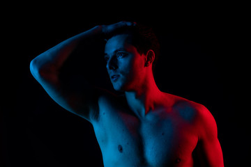 Man in studio with red and blue colors. Look at camera and smile