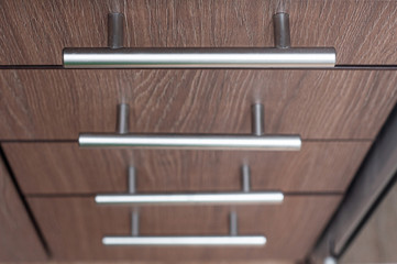Wood furniture handles with pull-out bedside tables. Aluminum trim handles in a minimalist style. Perspective in photography.