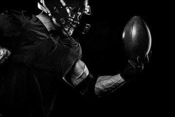 Sport concept. American football sportsman player on black background. Sport concept.