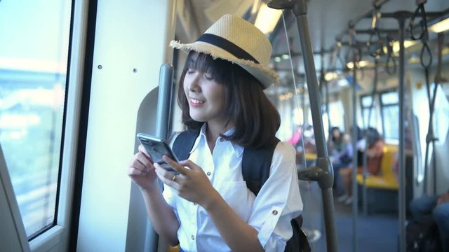 Travel concept. A beautiful woman playing on the phone while traveling by train. 4k Resolution.