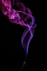 lilac smoke incense sticks on a black background. abstract figures of blue smoke on a black background