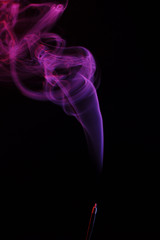 Obraz premium lilac smoke incense sticks on a black background. abstract figures of blue smoke on a black background