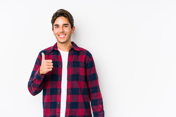Young caucasian man posing in a pink background isolated smiling and raising thumb up