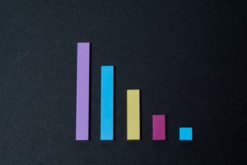 Colored decline graph on a black background. Colored blocks on a black background. Recession chart