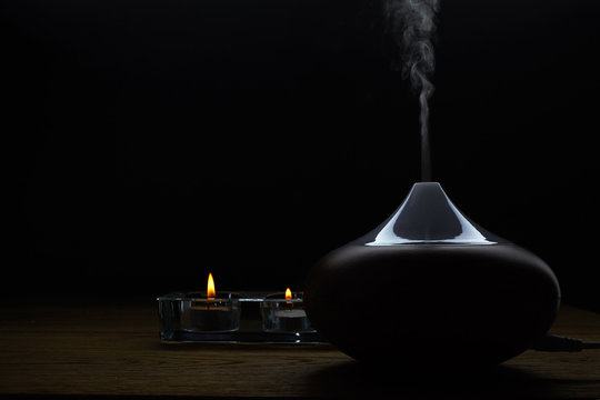 Aromatherapy. Essential oil aroma diffuser against dark background with copy space.
