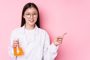 Young chinese scientific woman isolated smiling and pointing aside, showing something at blank space.
