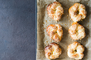 Baked fresh fragrant buns. Traditional homemade pastries. Pigtail buns top view.