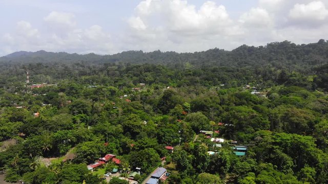 Aerial shot at Playa Negra Cahuita Costa Rica, starting with a shot of the village flying backwards ending at a shot of the coastline with the waves.