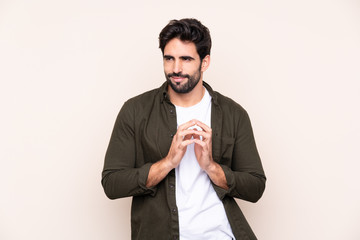 Young handsome man with beard over isolated background scheming something