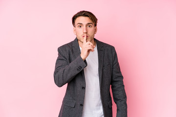 Young caucasian business man posing isolated keeping a secret or asking for silence.