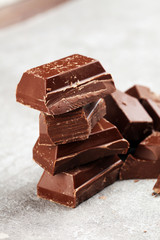 Dark chocolate stack, chips and powder with chocolate bars and block