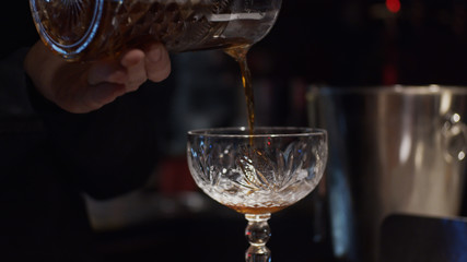 Pouring prepared cocktail into glass