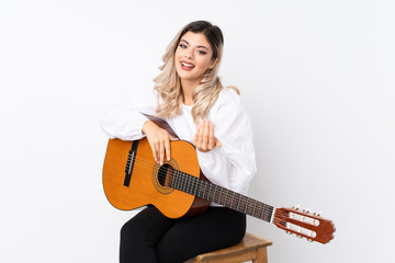 Fototapeta premium Teenager girl with guitar over isolated white background inviting to come with hand. Happy that you came
