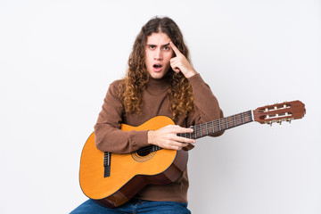 Young caucasian man playing guitar isolated showing a disappointment gesture with forefinger.