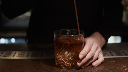 Pouring prepared cocktail into glass